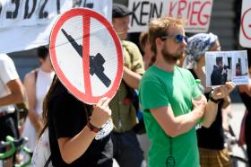 dimostranti con manifesti contro le armi
