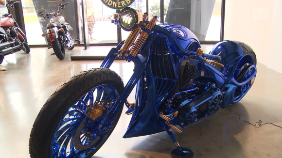 La moto protagonista del servizio (un Harley completamente blu con dettagli placcati oro) parcheggiata in obliquo