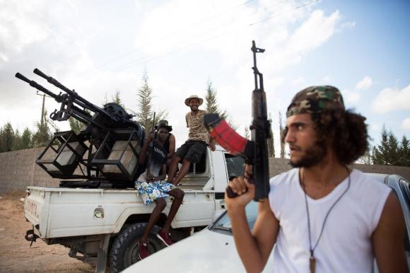miliziano con mitrra in mano e sullo sfondo un pickup con una mitragliatrice