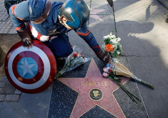 Uomo travestito da capitan america depone dei fiori sulla stella di Stan Lee nella Walk of fame di Hollywood