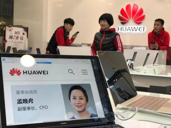 Suil bancone di un negozio di vendita Huawei, un PC aperto con la foto della responsabile delle finanze Meng Wanzhou.