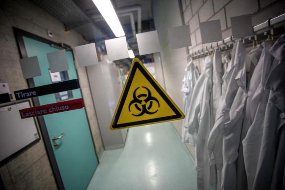 Il corridoio dell Istituto oncologico a Bellinzona: si vedono camici bianchi appesi e il logo dell atomo