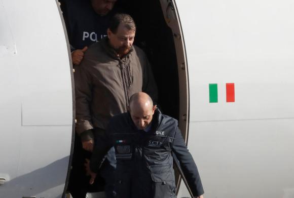 Cesare Battisti scortato da un agente davanti al portello dell aereo appena arrivato a Roma