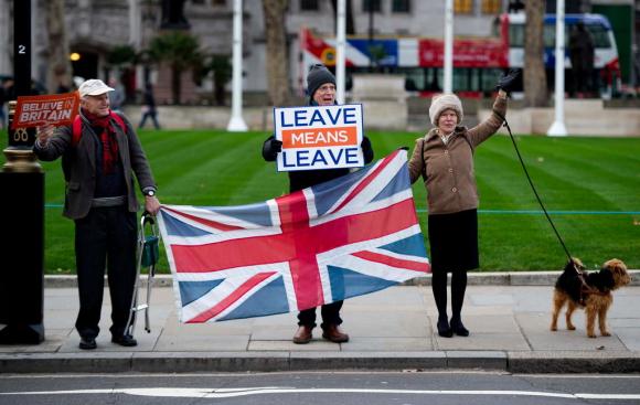 Un uomo con un cartello Leave means leave e una bandiera britannica