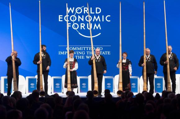 Sette suonatori del corso delle alpi sul palco del WEF per la sua apertura