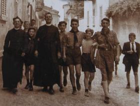 Foto d epoca con un gruppo di ragazzi scout e due preti