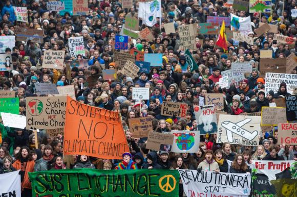 Immagine dall alto di un fitto corteo di giovani con cartelli di tutti i colori riportanti messaggi a favore del clima