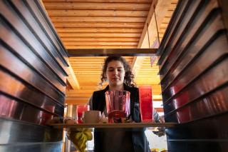A woman clears trays at a ski resort restaurant