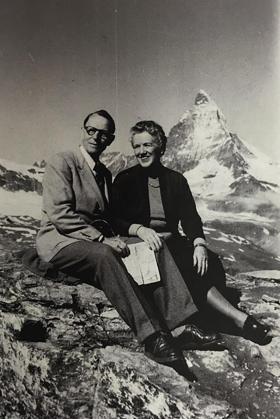 Un uomo e una donna seduti su un sasso in ambiente alpino