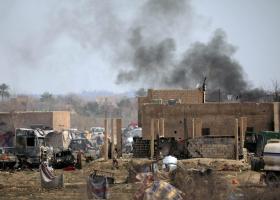 Umkämpfte IS-Bastion Baghuz. Schwarzer Rauch steigt über Häusern und Ruinen auf.