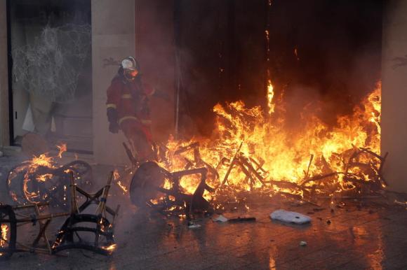 Il negozio Longchamps a Parigi che brucia e un pompiere che cerca di fermare il fuoco