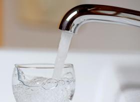 Primissimo piano di getto d acqua del rubinetto che entra in un bicchiere