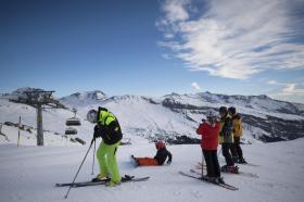 Un piccolo gruppo di sciatori su una pista da sci in una giornata di sole