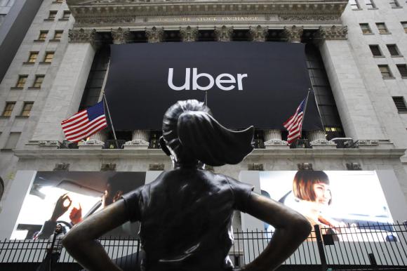 Faccia della borsa di New York, con esposto un drappo con stampato il logotipo di Uber, vista dal basso