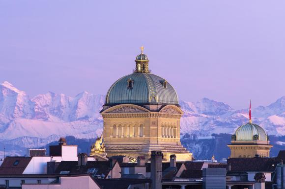La cupola di Palazzo federale presa nel tardo pomeriggio con dietro le Alpi bernesi colorate di rosa