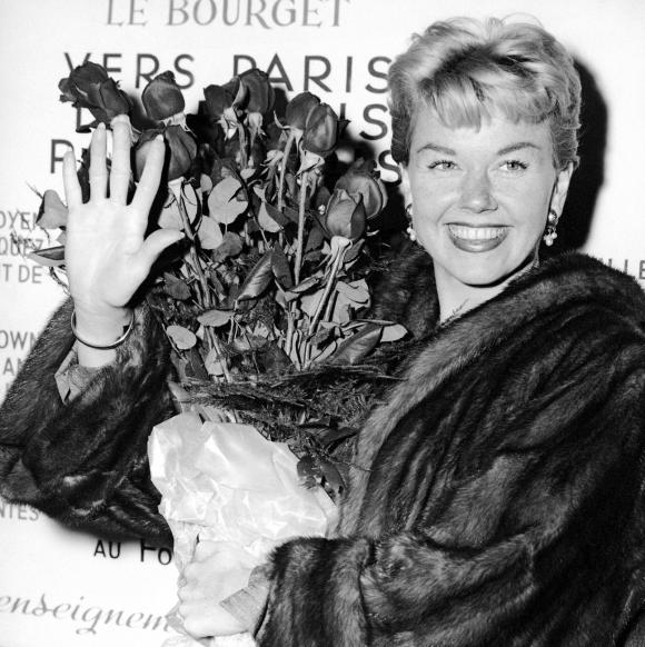 Doris Day tutta sorridente con un mazzo di rose fotografata nel marzo del 1955 all aeroporto francese di Le Bourget