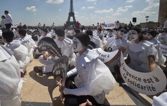 manifestanti anti eutanasia riuniti con sullo sfondo la tour eiffel