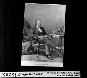 foto in bianco e nero di un uomo seduto su una sedia.