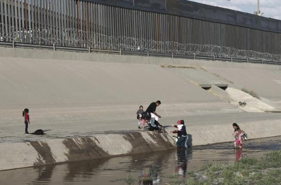 Migranti clandestini tentano di entrare negli Stati Uniti: nella foto si vede il muro che divide i due paesi