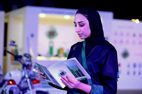 Una ragazza araba con in mano un libro per preparare gli esami di guida