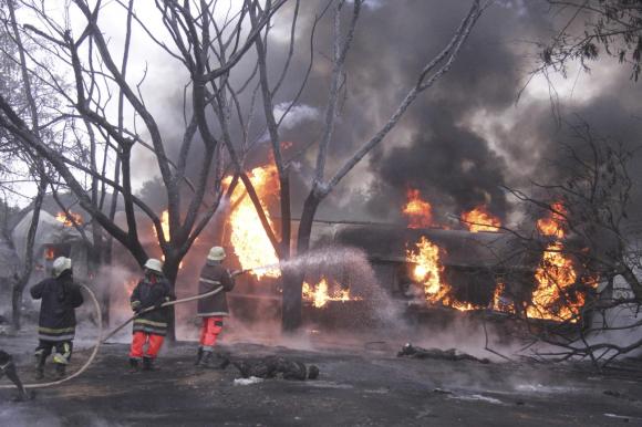 Tre pompieri impegnati a spegnere l autocisterna in fiamme