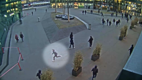 Immagine (stile telecamera di sorveglianza) di una piazza; evidenziata con un cerchio una persona che corre