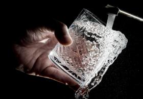 acqua sgorga da un rubinetto in un bicchiere