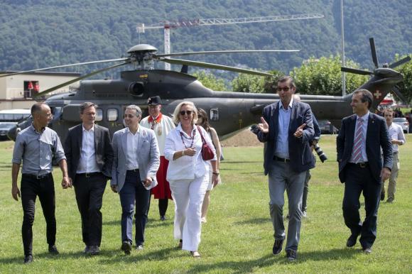 Des politiciens marchent sur de l herbe devant un hélicoptère