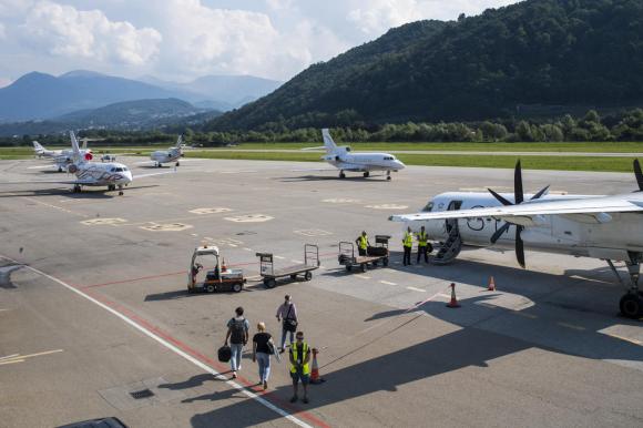 La pista di Lugano Agno: si vedono diversi aerei e personale dell aeroporto.