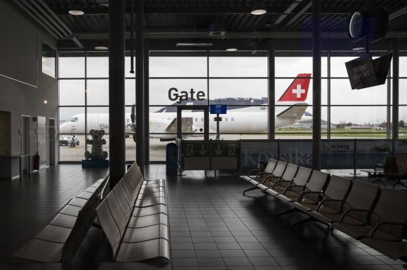 Il terminal di Berna Belp: si vede un aereo a terra e la sala d attesa completamente vuota.