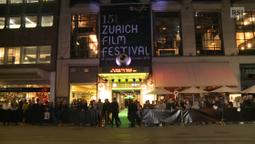Entrata di una sala verosimilmente teatrale con cartello Zurich Film Festival e corridoio con tappeto verde