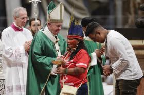Papa Francesco mentre davanti a lui sfilano persone in rappresentanza dei popoli amazzonici.