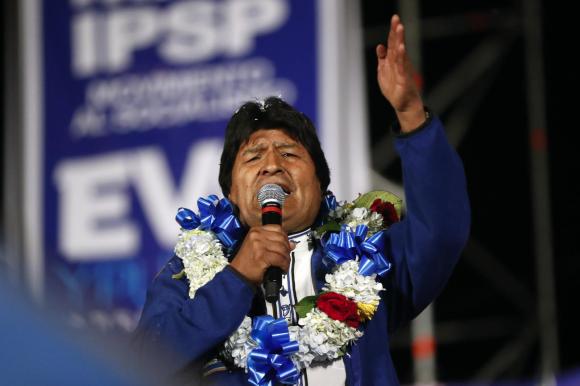 Evo Morales con una corona di fiori al collo durante un comizio politico.