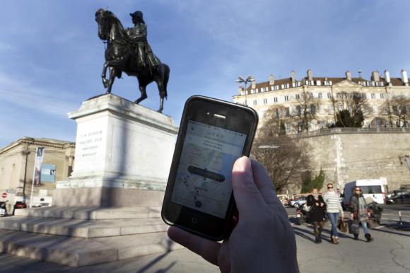 Telefono con App Uber in una piazza di Ginevra
