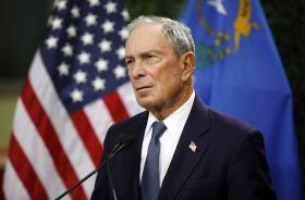 Un ritratto di Michael Bloomberg con dietro la bandiera americana