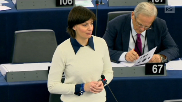 Lara Comi in maglione bianco e colletto blu, mani conserte, durante un intervento all europarlamento