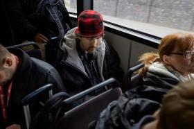 Benommener Mann mit roter Mütze im Bus
