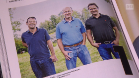 Tre uomini in abbigliamento casual su una fotto stampata su una pagina di magazine con scritta 1