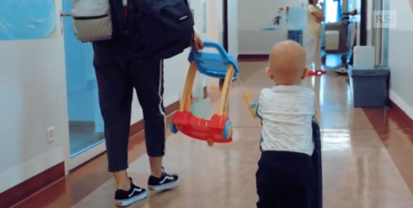 Bimbo malato cammina in un corridoio di ospedale.