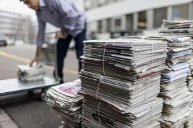 Pile di giornali legati pronti a essere raccolti per il riciclaggio della carta.
