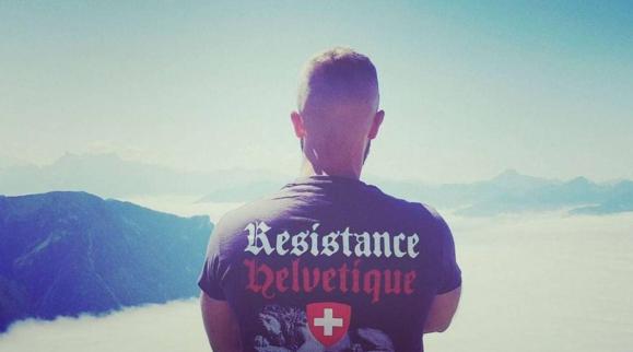 Un uomo visto da dietro con una t-shirt con la scritta Résistence Helvétique