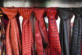 Diverse cravatte di seta annodate e appese su un filo