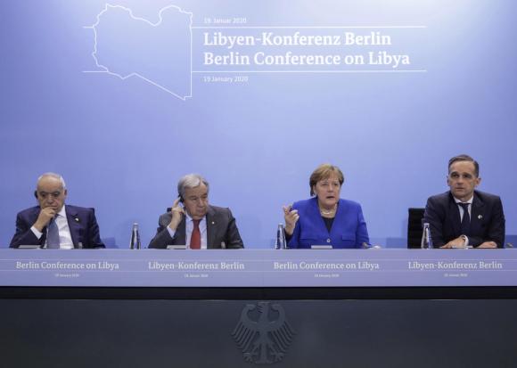 Tavolo di conferenza stampa con, sullo sfrondo, logo della Conferenza. Seduti una donna e tre uomini.