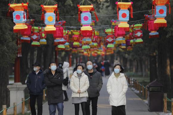 Giovani camminano con mascherina sul viso per il Parco Jingshan a Pechino