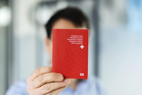 uomo mostra passaporto svizzero