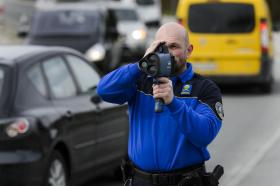 Un poliziotto misura la velocità con un radar-cannocchiale