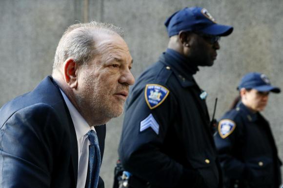 Weinstein mentre entra in tribunale scortato da poliziotti.