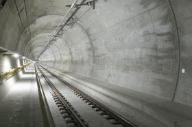 Immagine di un tunnel di cui non si vede l uscita con binari, cavi e volta di cemento armato ancora pulito