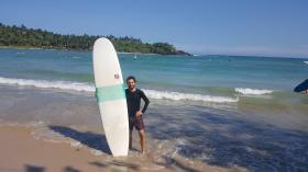 Daniel Gehr con una tavola da surf in spiaggia.