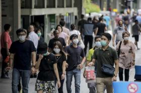 Le strade si Singapore piene di gente con la mascherina sul viso.